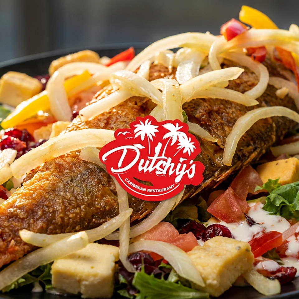 Whole fried fish topped with sautéed onions, served over a colorful Caribbean salad with vegetables and creamy dressing.